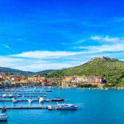 Porto Ercole village and boatd in harbor in a sea bay. Filippo fort on background. Aerial view. Monte Argentario, Tuscany, Italy
