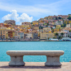 Bench on seafront in Porto Santo Stefano harbor, Monte Argentario, Tuscany, Italy.